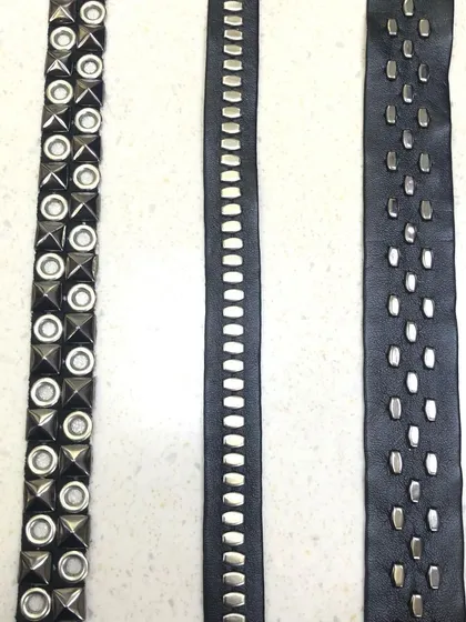 Three styles of modern studded laces on a black leather-like base. These trims are perfect for adding detail to jackets, trousers, or accessories for a contemporary, edgy look.