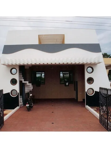 A frontal view of the CC Office's covered parking entrance. The wave-like motif and porthole windows were playful yet structural details that gave the building a distinct character, especially for its coastal location.