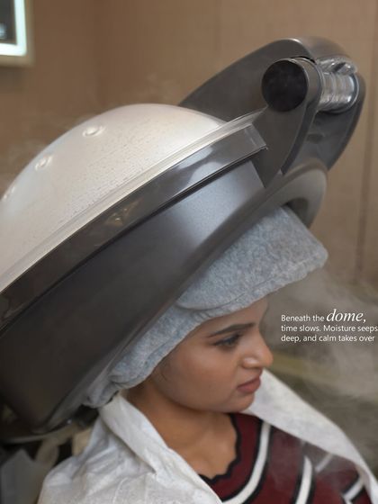 Beneath the dome of the hair steamer, time slows down. This step helps moisture from treatments seep deep into the hair shaft for maximum effectiveness.