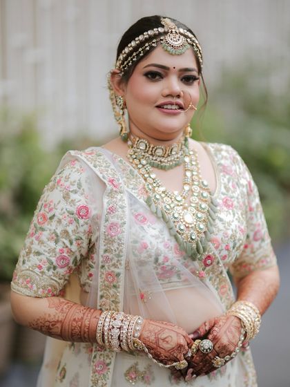 This bride chose a beautiful pastel green Kundan set from our rental collection to match her elegant floral lehenga, perfect for a day wedding.