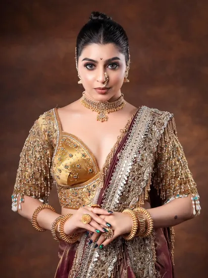 A powerful and direct portrait that makes a statement. The model's confident gaze and the stunning gold jewelry create an image of a strong, modern bride.