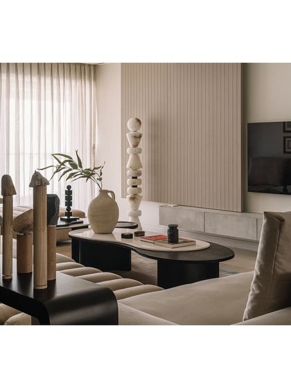 A different angle of the living room, highlighting the sculptural stone lamp and the organic shapes of the coffee table.