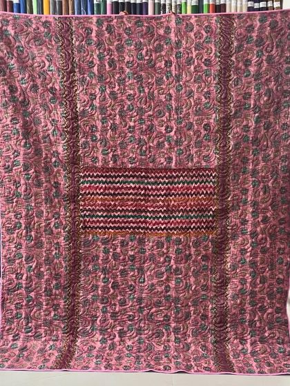 A reversible memory quilt made with a mother's sarees, this side featuring a beautiful pink fabric.