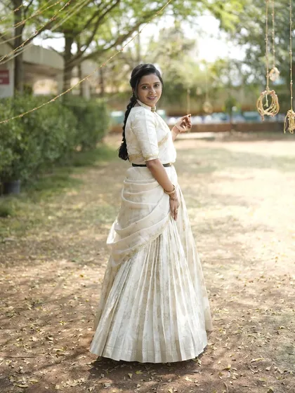 My dear friend Nithya shines in this custom-made light gold lehenga. I designed it with a modern, draped dupatta that can be belted at the waist, creating a look of effortless elegance for her special event.