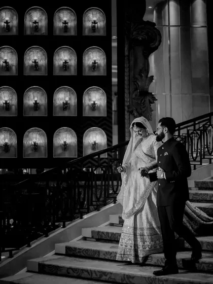 The quiet grace of a Nikah ceremony. This black and white photo of the couple on the stairs captures a moment of serene elegance and the beginning of their journey together.