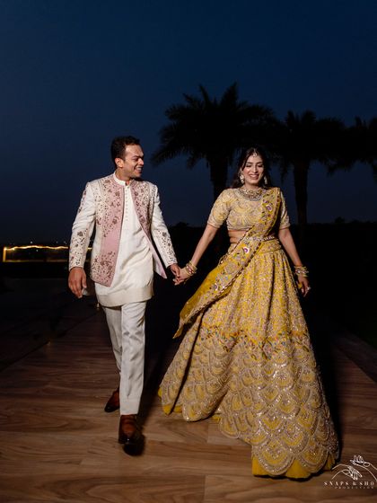 Walking hand-in-hand into their future. This shot captures the beautiful movement of their coordinated engagement outfits, designed for a stylish and comfortable evening.
