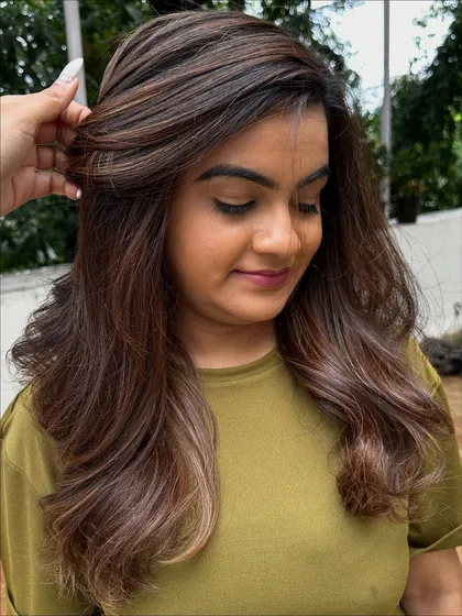 Getting her 'Vacay Hair' on with these beautiful ribbon highlights. This technique creates a gorgeous, flowing look that’s perfect for showing off on your next trip.