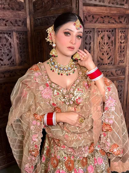 A close-up of the bride's face, her bold wing eyeliner and blushed cheeks perfectly complementing her jewelry.