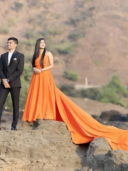 Our long-tail gowns, like this beautiful orange one, are available for rent at budget-friendly prices. They are perfect for creating high-impact pre-wedding photos.