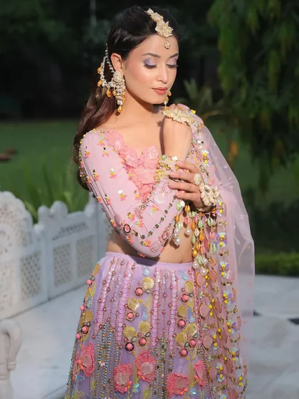 A full view of this trendsetting Mehendi look. The pastel floral lehenga is paired with bold eye makeup, creating a look that is both whimsical and glamorous.