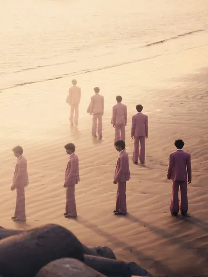 A wide shot showing the progression of the figure against the golden light of the sea. It's a visual poem about journeys, both internal and external.