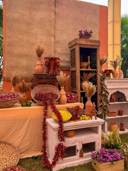 A display of rustic wooden and whitewashed furniture, decorated with spices, flowers, and terracotta elephants, contributing to the eclectic charm of the bazaar.