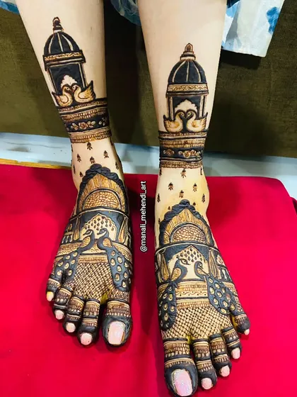 This foot mehandi design features graceful swans inside a dome at the ankle. The top of the feet are covered with elaborate peacock figures, creating a rich and royal look.