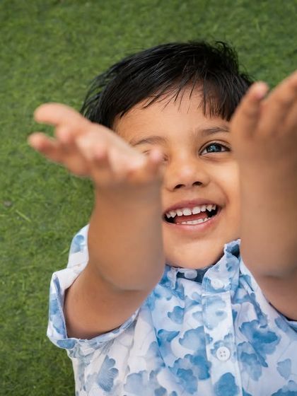 A playful, high-angle shot of a boy with a huge, happy grin. This perspective adds a fun and dynamic feel to the portrait.