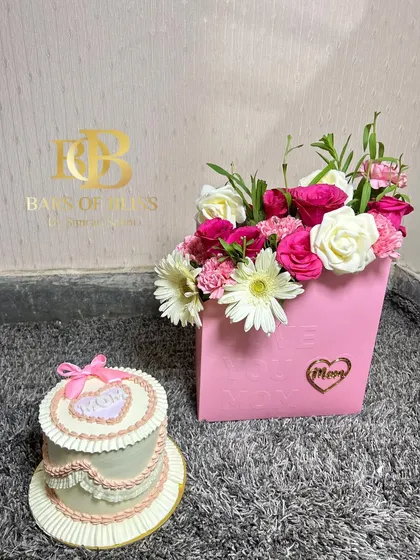 A vintage-style heart-shaped cake for Mom, paired with a beautiful pink box of fresh flowers.