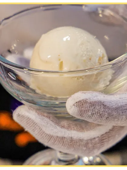 A perfect, simple scoop of vanilla ice cream held in a glass, ready for toppings. Our live dessert counters are always a hit.