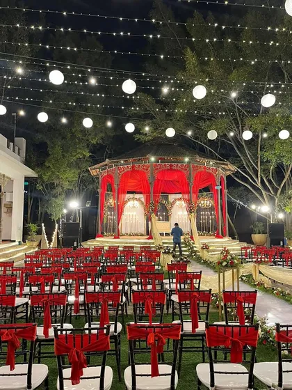 Another angle of the stunning red and white reception decor, showing the meticulous planning of the seating and stage.