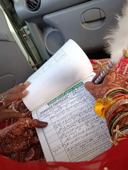 Being part of the 'Qubool Hai' moment is the greatest honor. Here, a bride's henna-adorned hands sign her marriage certificate, marking the beginning of a new journey.