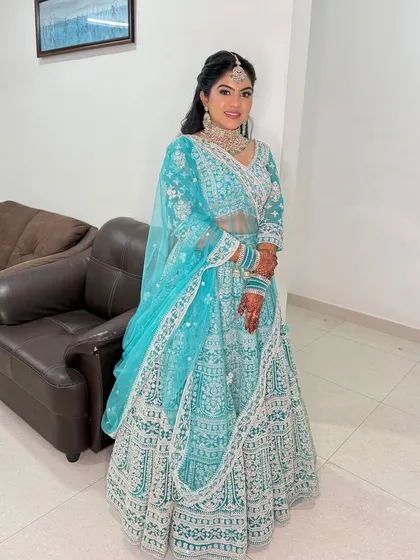 A full-length view of the bride in her turquoise ensemble. The makeup is designed to make her glow from within.