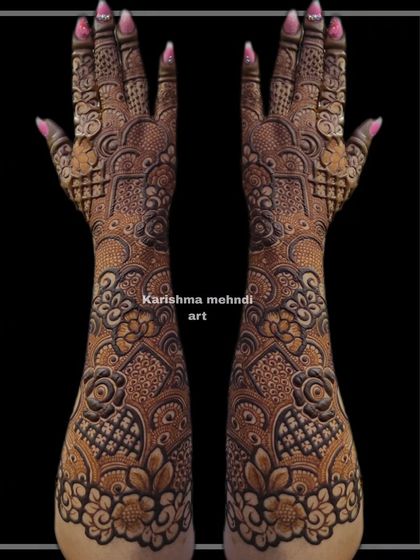 Another example of a heavy Indo-floral design, this mehendi features layers of intricate patterns from the elbow to the fingertips. The symmetrical layout ensures a balanced and cohesive look.