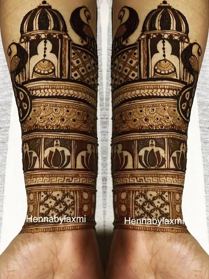 Symmetrical palace and peacock designs on the forearms. This architectural style of mehandi gives a very royal and grand appearance.