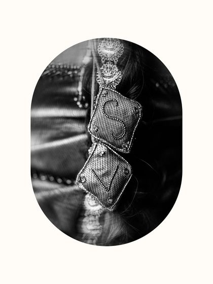 A detailed black and white shot of the couple's initials on a piece of the bride's attire, a beautiful personal touch.