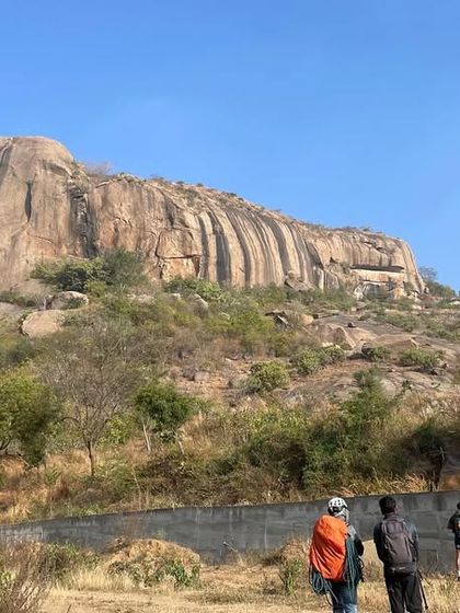 A group of climbers at the base of Talai Betta, with a local cow looking on. It's a classic Ramanagara scene.