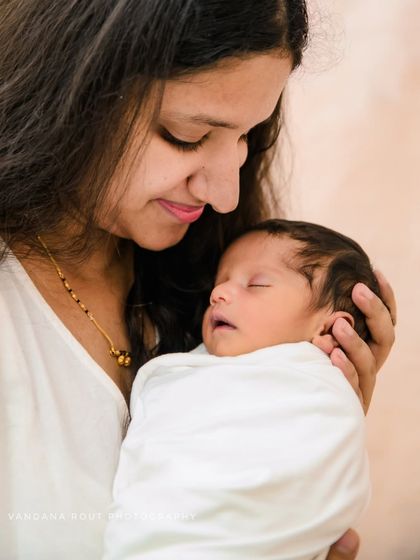 A close-up shot of a mother gazing lovingly at her sleeping newborn. These tender, quiet moments are the heart of my newborn photography sessions.