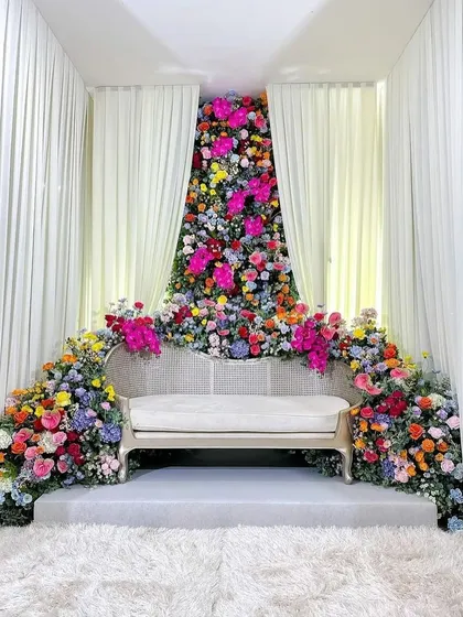 People hear 'Balloon World' and think we only do balloons. This vibrant, floor-to-ceiling floral installation proves otherwise. I used a rich variety of fresh, colorful flowers to create a breathtaking seating area for an engagement.