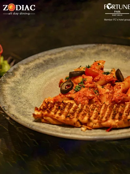 A unique offering from our kitchen, this dish features pasta served on a slice of grilled bread, combining textures and flavors.