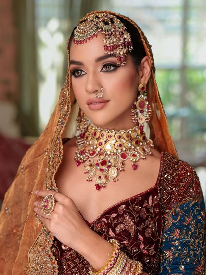 A stunning close-up with the dupatta framing the face. The kohl-rimmed eyes and perfectly sculpted features create a look of royal elegance.