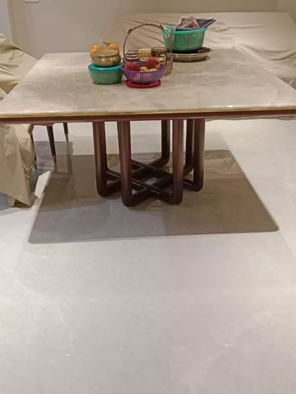 This is a custom four-seater square dining table with a marble top and an intricate interlocking wooden base. It's a great example of how I can create stylish solutions for smaller spaces.