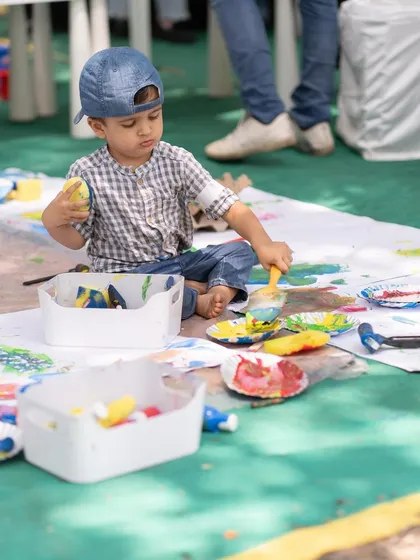 A young boy gets lost in a world of color and texture at our messy art station. Activities like these are designed to be completely child-led, allowing them to explore and express themselves without any rules.