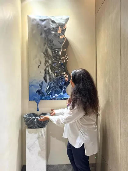 This abstract, metallic wall sculpture is a true conversation starter. Paired with a smaller sculpture on a pedestal, it creates a modern and artistic entryway. I love how it plays with light and reflection.