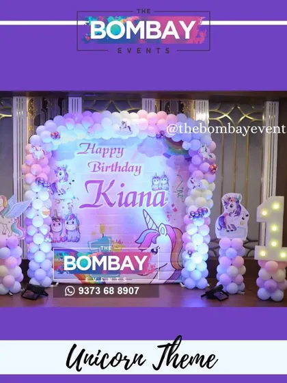 A magical unicorn theme for Kiana's first birthday. This beautiful setup features a custom backdrop, a pastel balloon arch, unicorn cutouts, and a light-up number '1'.