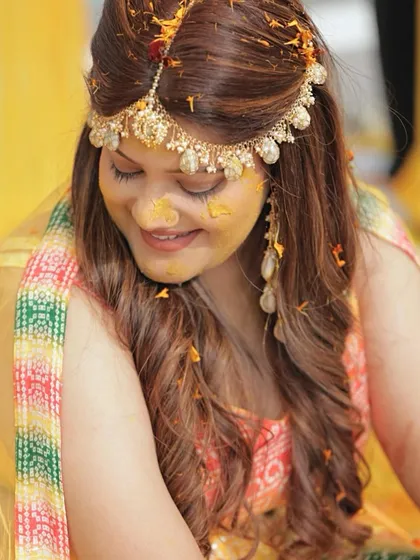 A candid shot of Ishita during her Haldi ceremony, with turmeric on her face. Her soft makeup still looks beautiful and intact.