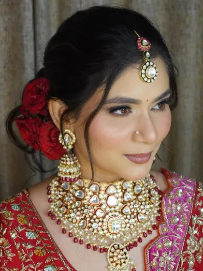 Another angle of the classic bridal look, highlighting the flawless makeup and the beautiful contrast of the red outfit and jewellery.