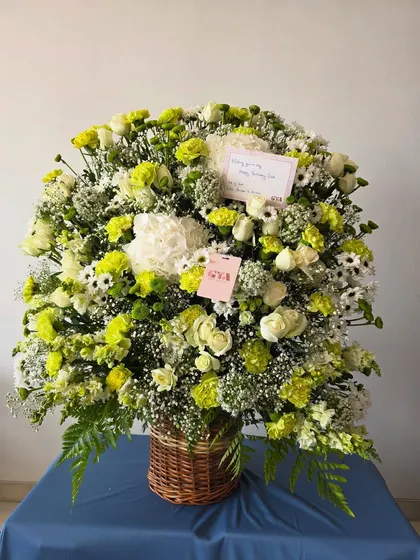 The full view of the white and green arrangement, showcasing its impressive size and lush, garden-like feel.