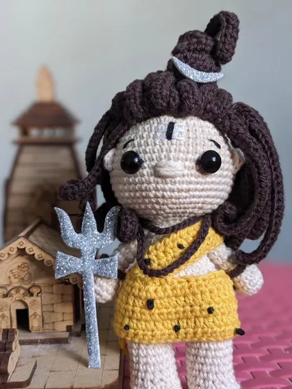 The Lord Shiva doll placed next to a small wooden temple, creating a devotional scene.