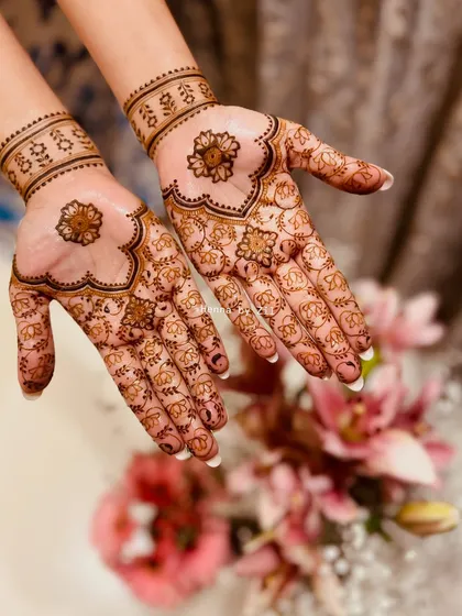 Subtle and sweet. This minimal bridal design features a lovely floral motif in the center of the palm with tiny elephants scattered around, paired with a simple wristband.