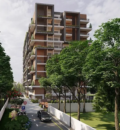 We visualize how a building sits within its environment. This view shows the tree-lined approach to a modern apartment complex, helping clients and buyers understand the full living experience, including the green spaces that surround their future home.