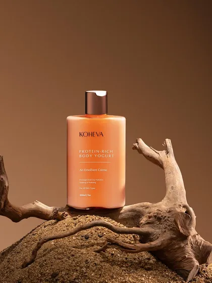 A wilderness-inspired setup for a body yogurt. We used golden sand and a piece of driftwood to create an earthy, natural environment that complements the product's ingredients.