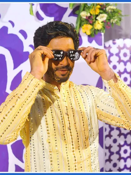 Shades on, Haldi mode activated. The groom having fun with customized sunglasses, adding a quirky touch to the ceremony.