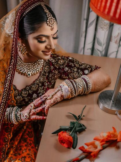 This artistic shot showcases the bride's complete look. The makeup is soft and timeless, designed to complement her intricate hairstyle and beautiful bridal attire.