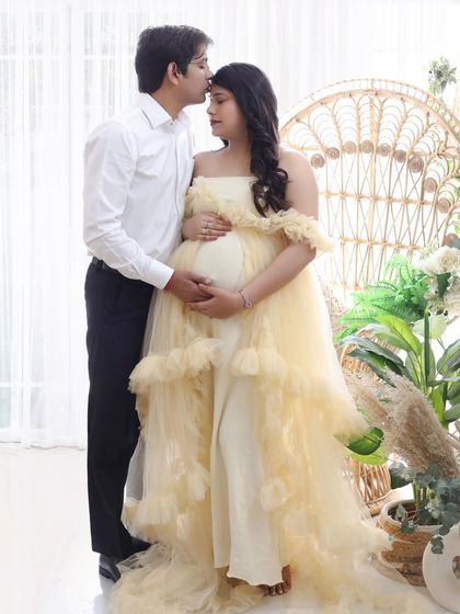 Love multiplied. This sweet couple portrait captures the dad-to-be kissing his partner's forehead, a simple gesture full of love and promise.