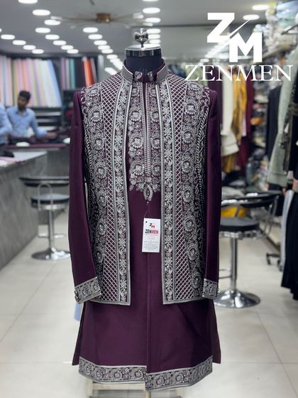 A regal Indo-Western outfit in a deep wine color. The heavily embroidered silver open jacket is layered over a matching kurta for a majestic look.