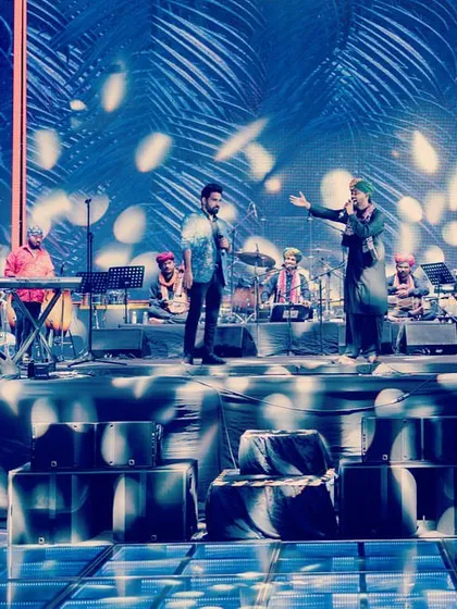 The full band on a stunningly lit stage during a private concert in Delhi.