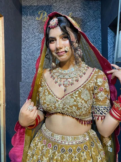 A close-up of our beautiful bride in a heavy golden-green lehenga. The intricate jewelry and nath complete her stunning look.