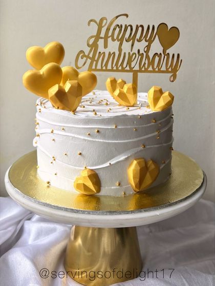 A simple yet elegant anniversary cake with textured buttercream and golden geometric hearts. This design is perfect for celebrating golden moments together.