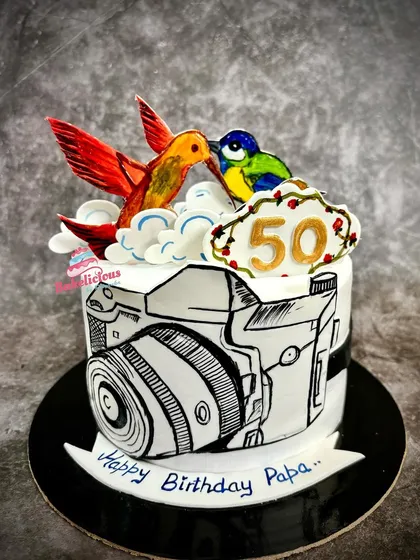 A truly unique, all-edible hand-painted cake created for a wildlife photographer's 50th birthday. The comic-style camera and colourful birds on top showcase my passion for turning your hobbies into delicious art.